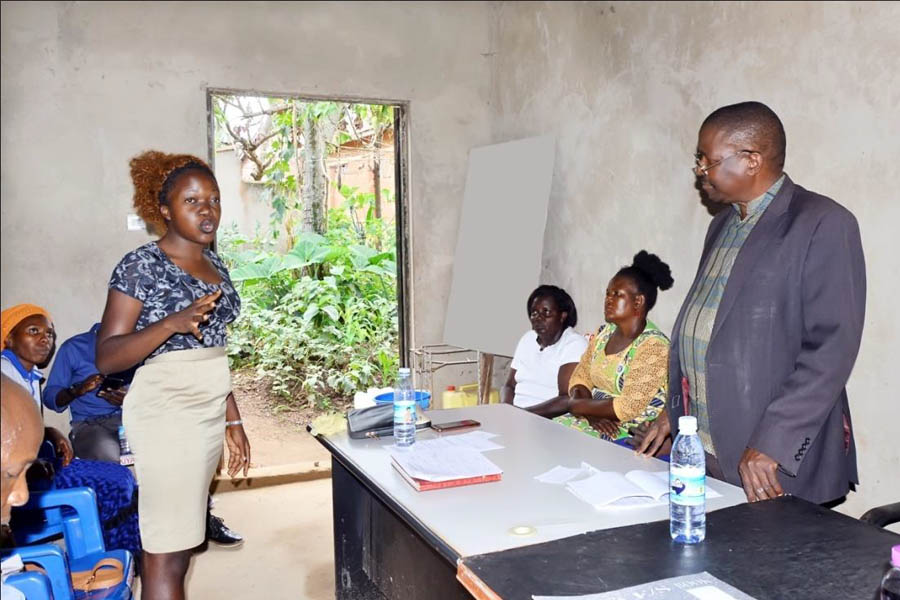 Ms Angel Nalubega, a community member from Bwaise(standing above) addressing the community meeting. Looking on is Dr J. Kimera Ssekiwanuka (on the Right) the Lead Facilitator