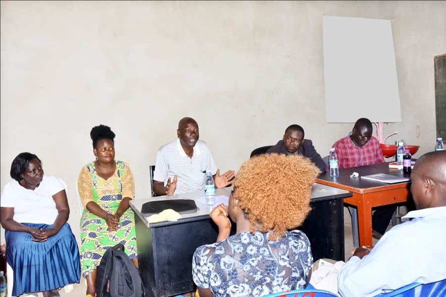 Mr. Ssekimpi Richard Mackay, the Councilor of Kanyanya Parish(seated centre above) addressing the community meeting.